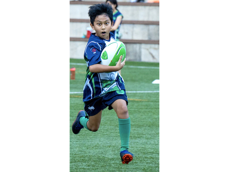 Dragons rugby club boy holding ball running