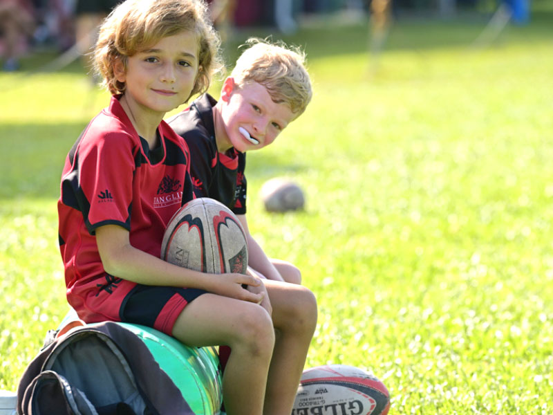 young boys taking break from rugby for kids on field