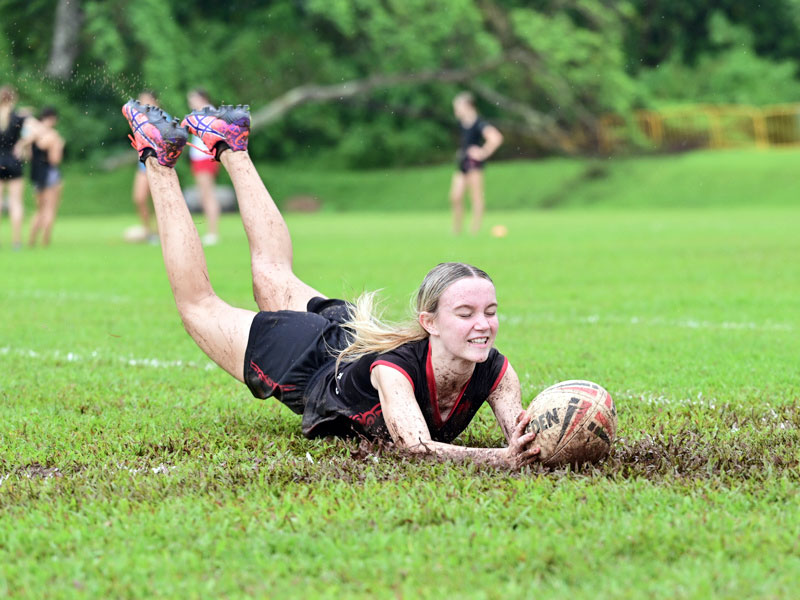 teenage girl diving for rugby on fieldball