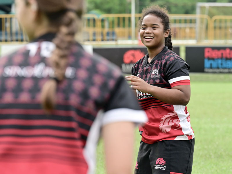 sports club Singapore teenage girl rugby for kids smiling on field