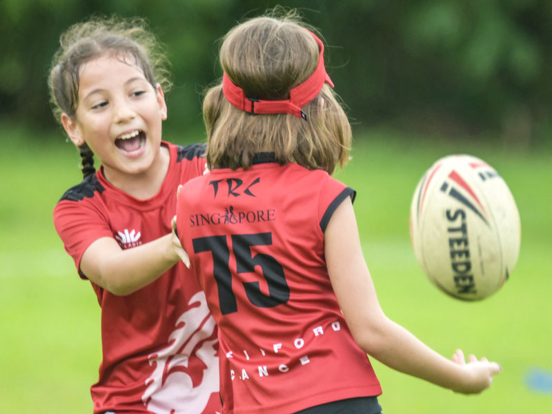 two girls enjoying rugby for kids outdoors