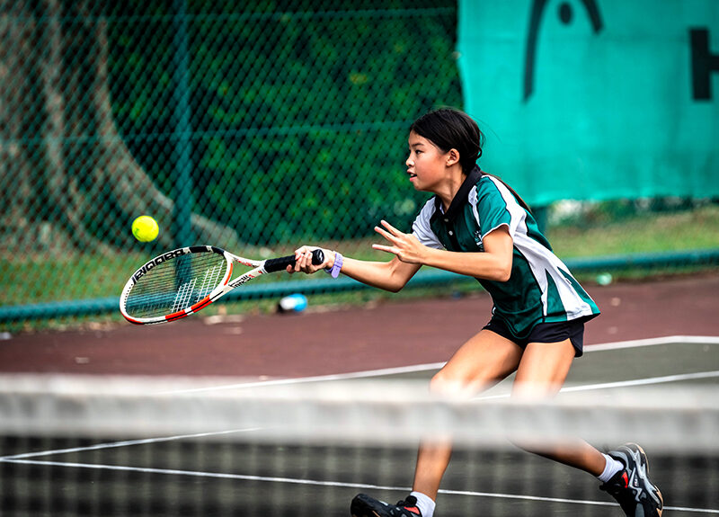 SJI International student practicing tennis SJI International student practicing tennis