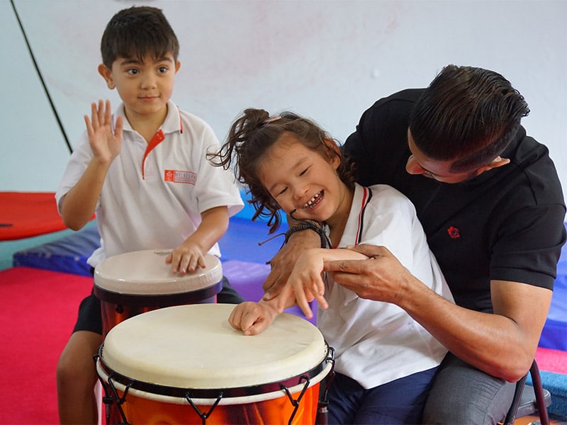 Image of MSIS teacher and students using drumming therapy