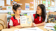 two CIS students learning a language French in class