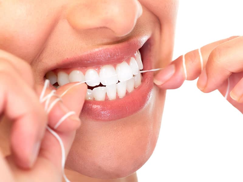 Woman flossing teeth straightening braces in singapore