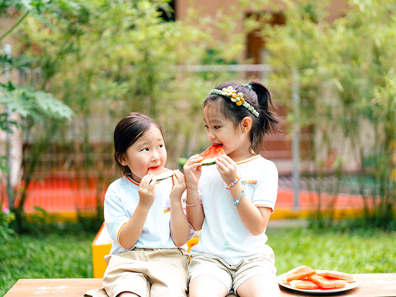 The Grange preschool kids eating watermelon outdoors