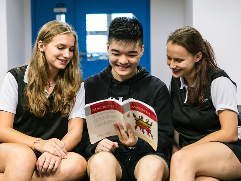 Canadian International School three high school students reading Macbeth international school curriculum