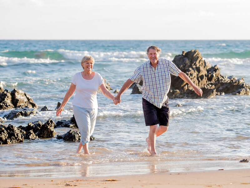 Pacific Prime travel insurance retired couple at beach