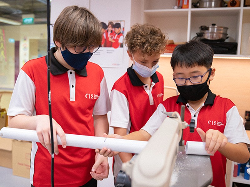 Canadian International School male students cutting a pipe during technology programmes