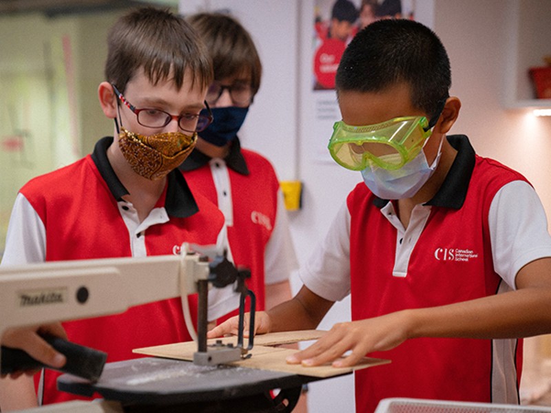 Canadian International School students using machine during STEAM workshop