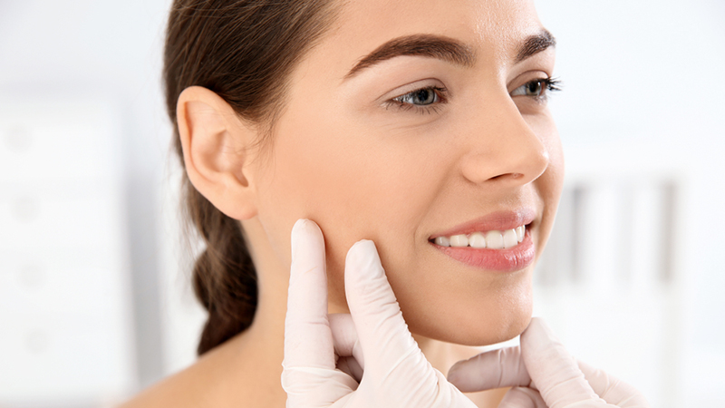 Woman having skin checked by dermatologist