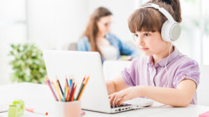 Girl online learning at home earphones laptop
