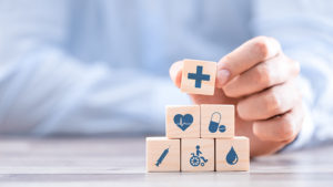 Health insurance maximising benefits and costs wooden blocks