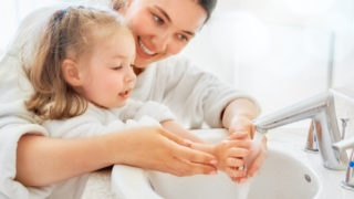 parent teaching child about hand hygiene and hand washing