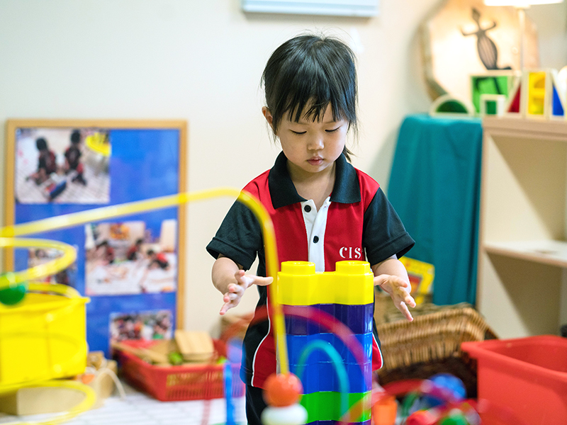 Canadian International School kindergarten singapore toddler female stacking blocks play-based learning