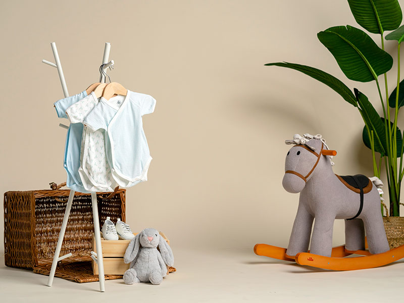 PreLouLou preloved designer baby rompers on rack with rocking horse