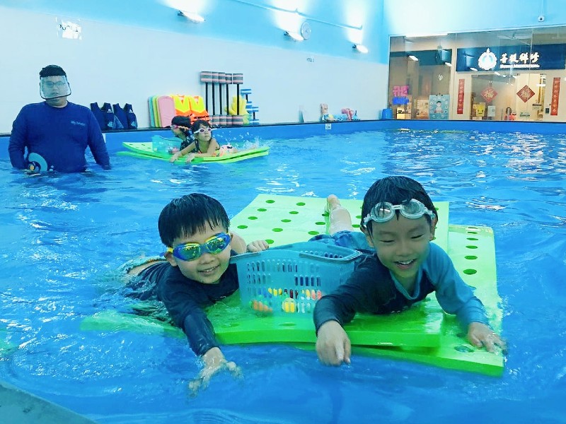Two boys Mosaic Preschool students at swimming class play based learning