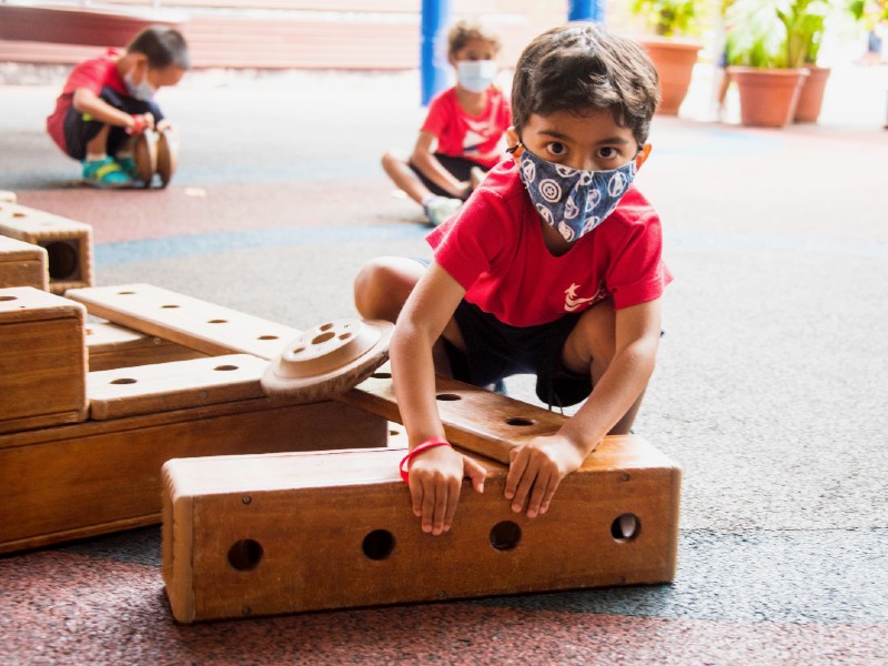 Singapore American School Early Learning Center nursery children playing with wooden construction outdoors