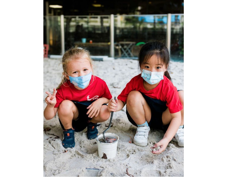 Singapore American School two pre-kindergarten girls playing in sand