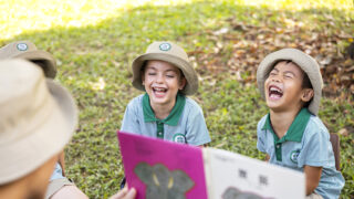 reading outdoors at SJI International Singapore on Holland Road